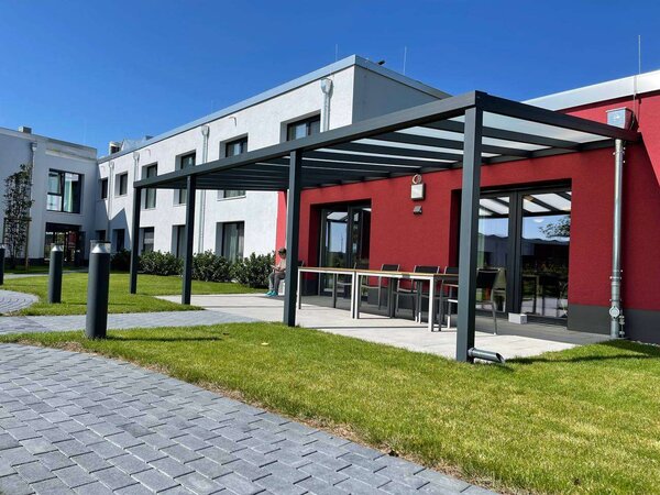 Seitenansicht Pergolamarkise als Terrassenüberdachung an Seniorentagesstätte