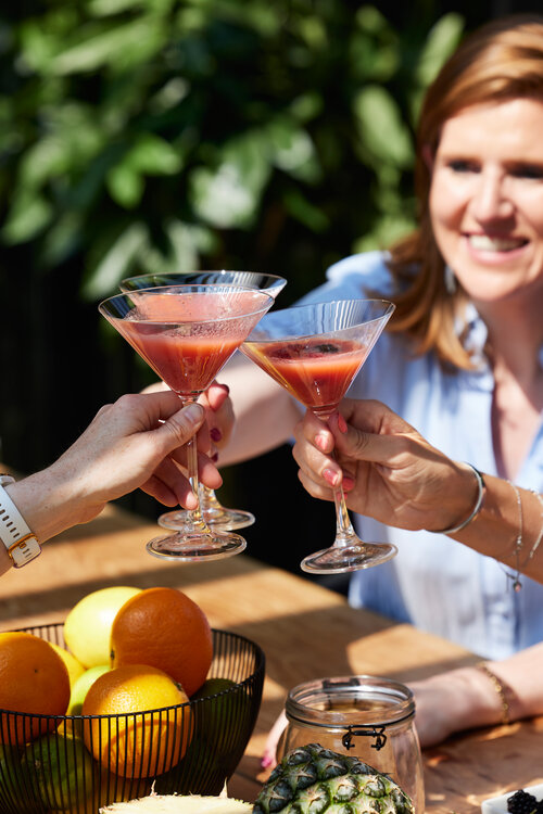 Unter Sonnenschutz genießen Frauen Cocktails